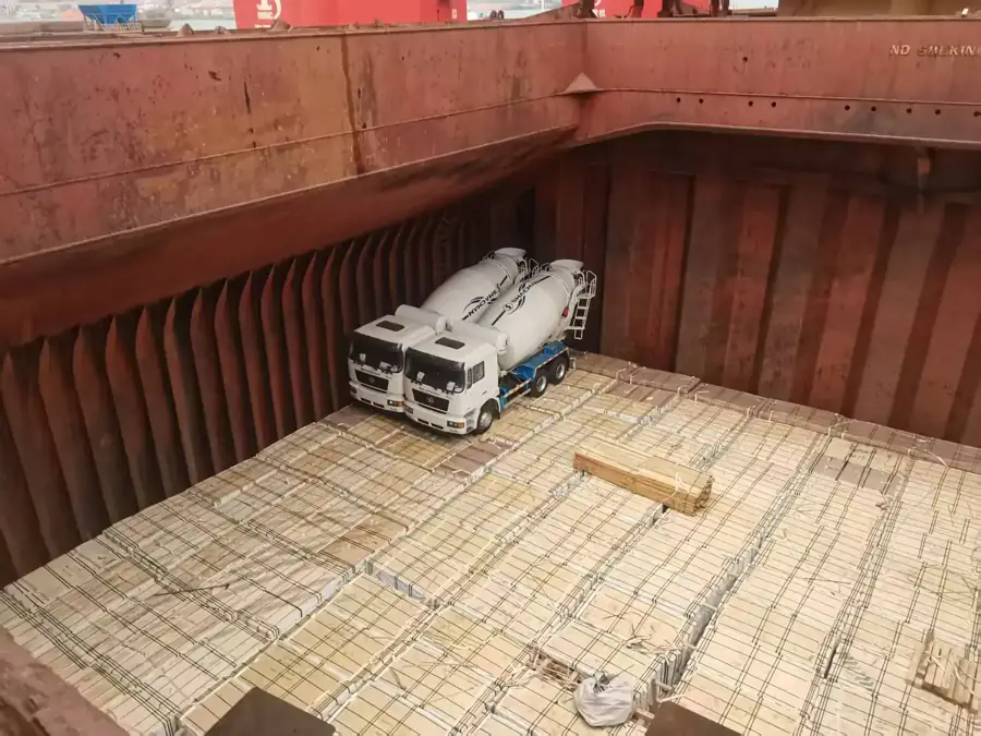 Heavy trucks being loaded onto an export vessel