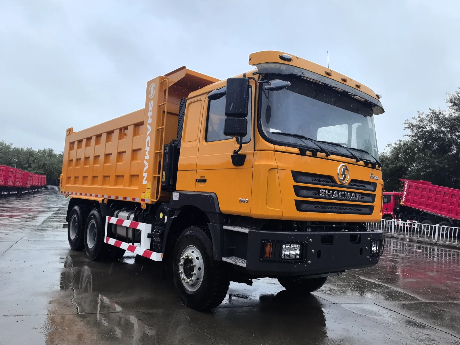 Yellow SHACMAN dump truck, front three-quarter view
